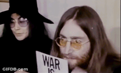 Man Holding Sign Saying War Is Next To Woman GIF