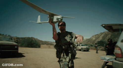 Man Holding Small Plane With Letter L GIF