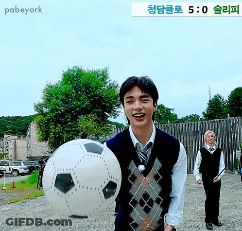 Man Holding Soccer Ball In Front Of Pabeyork Sign GIF