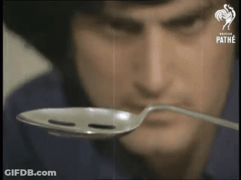 Man Holding Spoon In Front Of Face Saying Pathe GIF