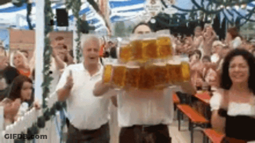 Man Holding Stack Of Beer Mugs In Front Of Crowd GIF