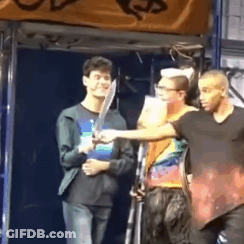 Man Holding Sword Next To Another GIF