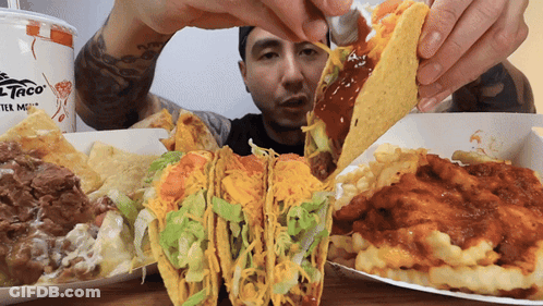 Man Holding Taco In Front Of Del Taco GIF