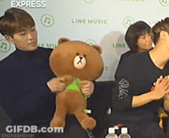 Man Holding Teddy Bear In Front Of Express Wall GIF
