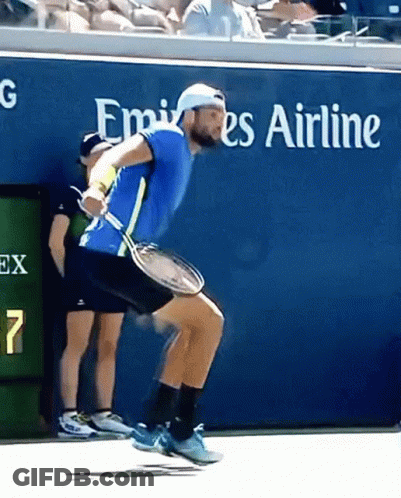 Man Holding Tennis Racket In Front Of Emirates Sign GIF