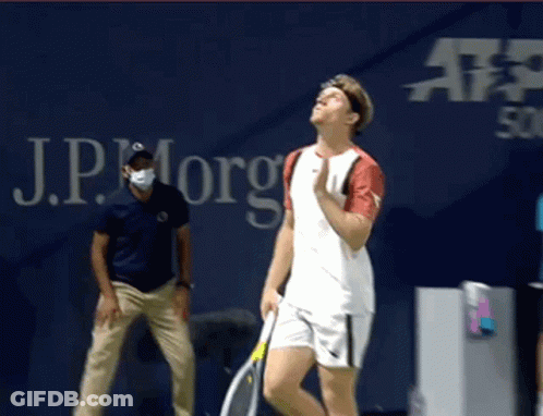 Man Holding Tennis Racquet In Front Of JP Morgan Sign GIF