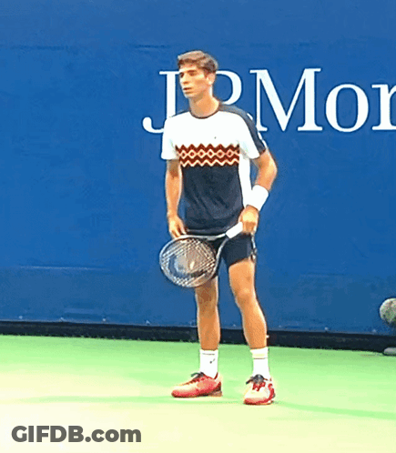 Man Holding Tennis Racquet In Front Of JPMorgan Sign GIF