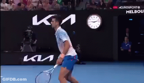 Man Holding Tennis Racquet In Front Of KM Sign GIF