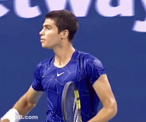 Man Holding Tennis Racquet In Front Of Localiza Sign GIF