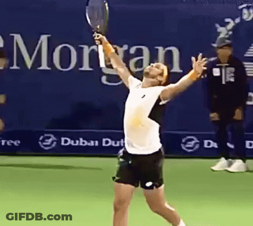 Man Holding Tennis Racquet In Front Of Morgan Sign GIF