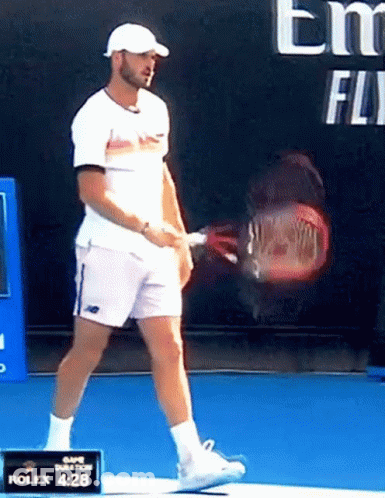 Man Holding Tennis Racquet In Front Of Rolex 4:28 Sign GIF