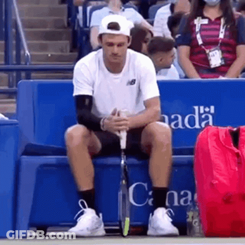 Man Holding Tennis Racquet In Front Of Rolex Sign 4:28 GIF