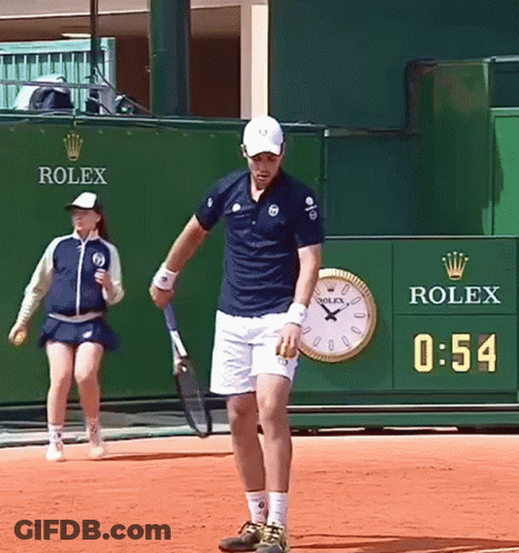Man Holding Tennis Racquet In Front Of Rolex Wall GIF