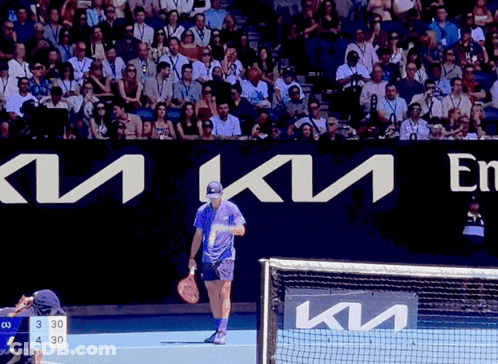 Man Holding Tennis Racquet On Court With Kia Sign GIF