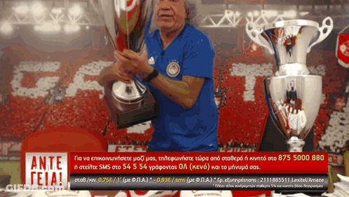 Man Holding Trophy Beside Ante Sign GIF