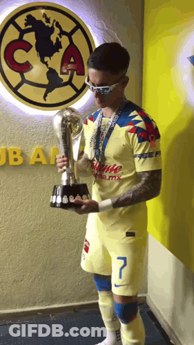 Man Holding Trophy In Front Of Club America Wall GIF