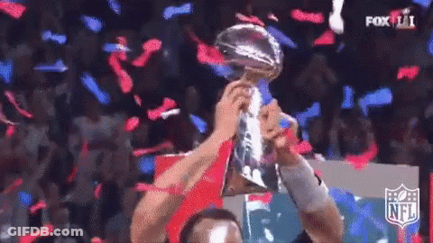 Man Holding Trophy In Front Of Crowd With Confetti GIF