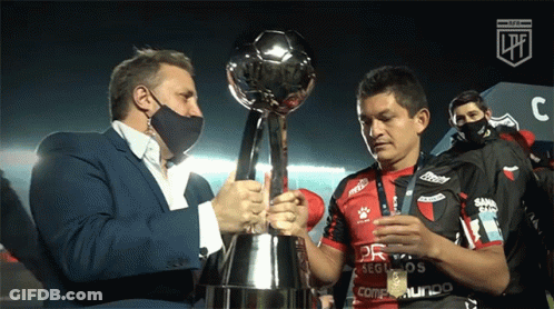 Man Holding Trophy Next To Jersey GIF