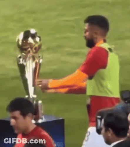 Man Holding Trophy On Soccer Field GIF