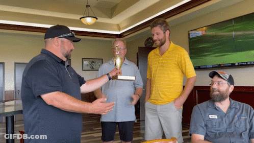 Man Holding Trophy Talking To Two Men GIF