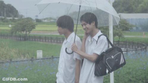 Man Holding Umbrella Next To Man With Bag GIF