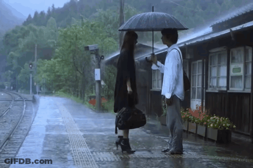 Man Holding Umbrella Next To Woman In Rain GIF