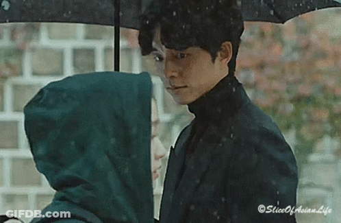 Man Holding Umbrella Over Woman In Rain GIF