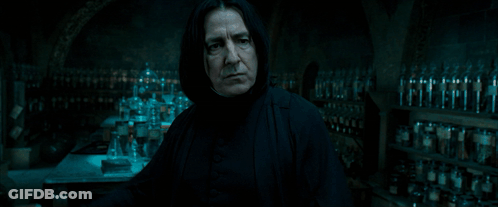 Man Holding Wand In Dark Room With Bottles GIF