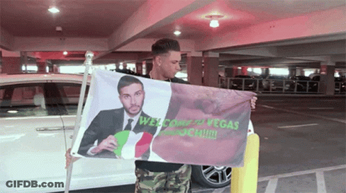 Man Holding Welcome To Vegas Flag GIF