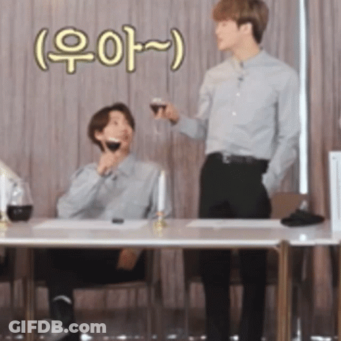 Man Holding Wine And Another Man At Table GIF