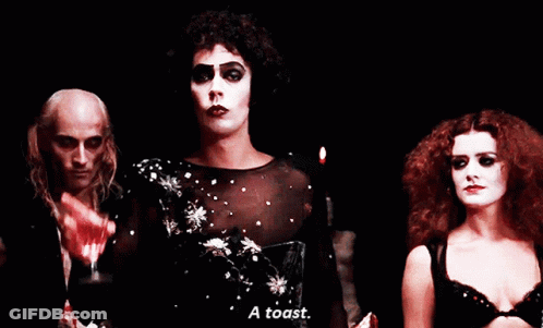 Man Holding Wine Glass Says A Toast Next To Two Women GIF