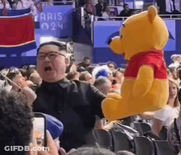 Man Holding Winnie The Pooh In Crowd GIF