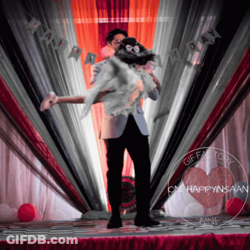 Man Holding Woman At Happy Day Sign GIF