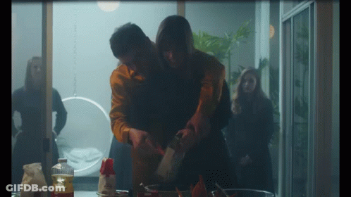 Man Holding Woman's Arm While Cooking GIF