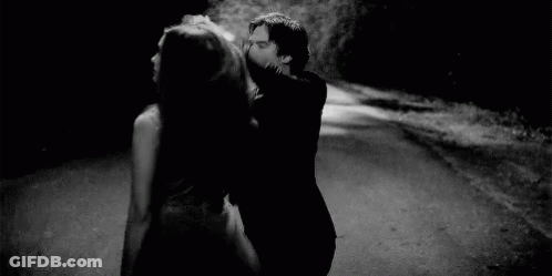 Man Holding Woman's Hair While Dancing On Road GIF