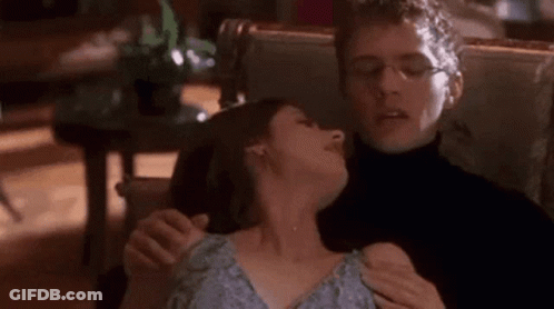 Man Holding Woman's Neck In Chair GIF