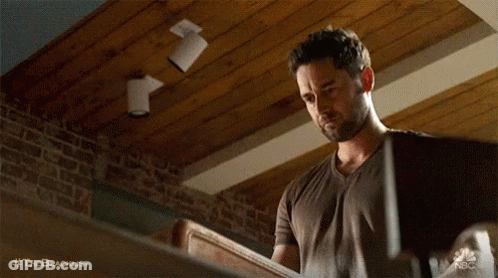 Man Holding Wood With Brick Wall And Wooden Ceiling GIF