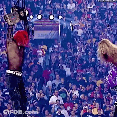 Man Holding World Heavyweight Championship In Front Of Crowd GIF