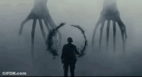 Man Holding Wreath In Front Of Monster In Fog GIF