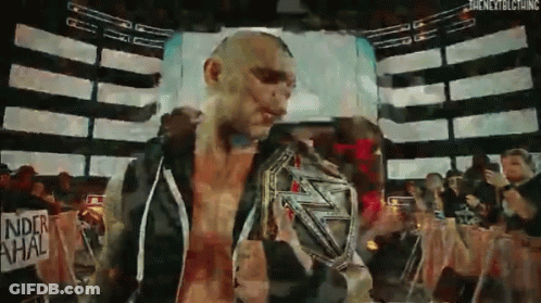 Man Holding Wrestling Championship Belt In Front Of Crowd GIF