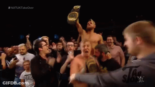 Man Holding Wrestling Championship Surrounded By Fans GIF