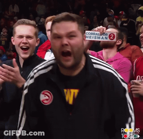 Man Holds Sign Saying Corral For Heisman GIF