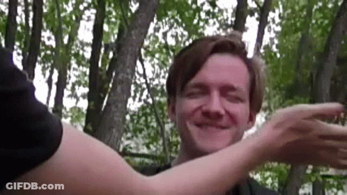 Man Hugged By Woman In Woods Smiling GIF