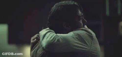 Man Hugging Another Man Holding Head Dark Room GIF