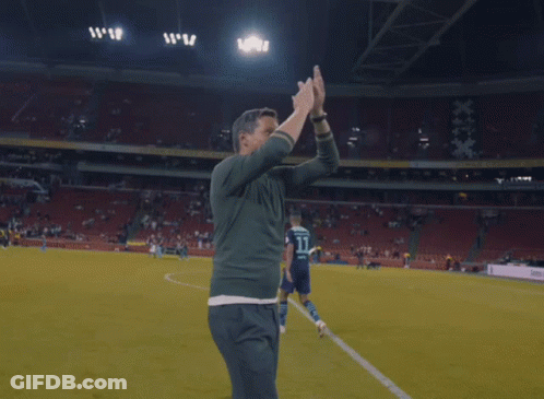 Man Hugging Man On Soccer Field With TB Shirt GIF