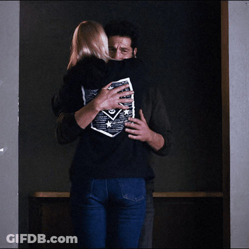 Man Hugging Woman In Black Skull Shirt GIF