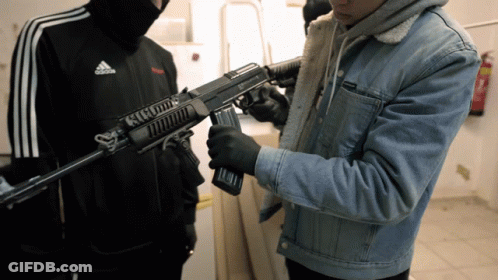 Man In Adidas Jacket Holding Rifle GIF