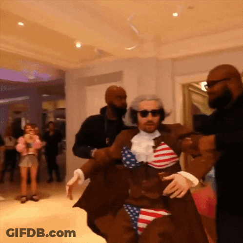 Man In American Flag Costume Escorted By Two Men GIF