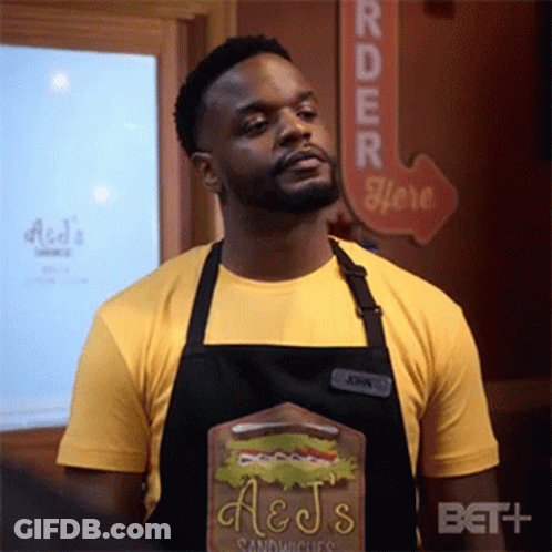 Man In Apron And Yellow Shirt With Sandwich Board GIF