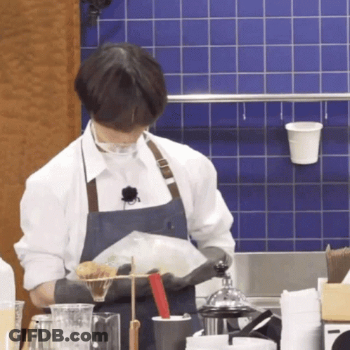 Man In Apron Holding Bag Of Food GIF
